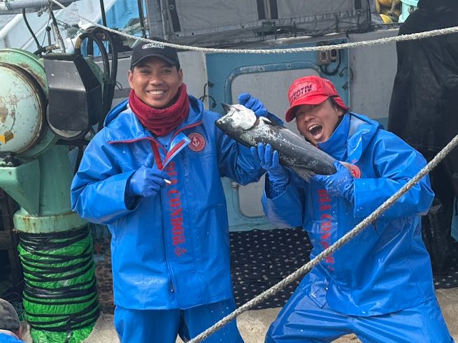 魚を持って笑顔